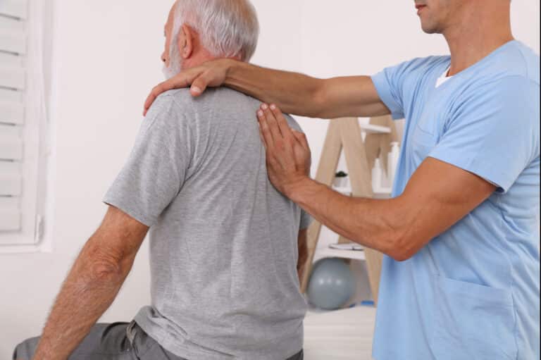man receives physical therapy for upper back pain