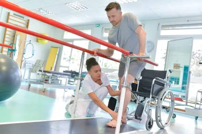 Man practices walking with PT in inpatient rehab physical therapy